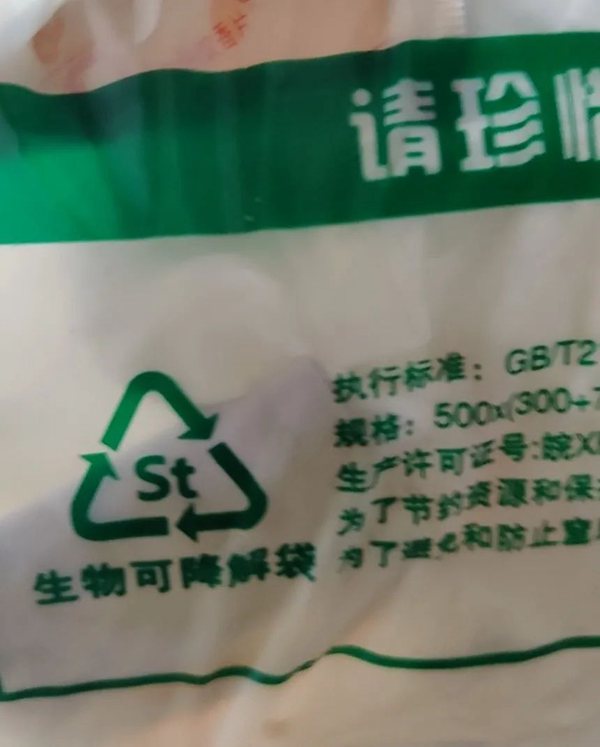 南京科巷菜场的生物可降解袋子上印有回收标志（箭头三角形表示回收，St表示淀粉）
